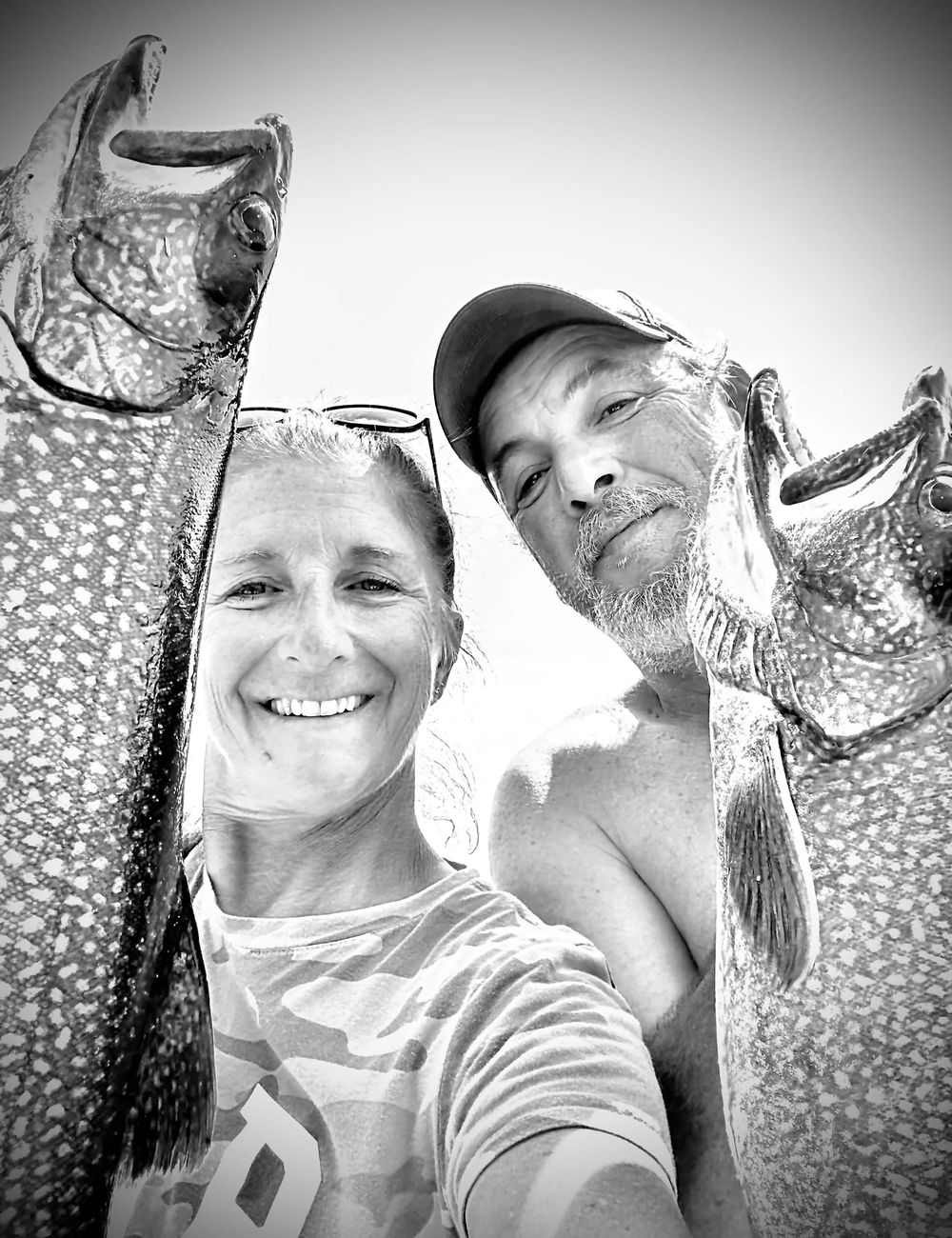 Two anglers holding up a pair of lake trout